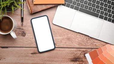 Üst görünümde akıllı telefon ve dizüstü bilgisayarı tasarım çalışma alanı üzerine modelle.