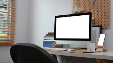 Cozy workplace with computer, smart phone and in home or house office interior.