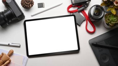 Tasarımcı çalışma alanı üzerinde dijital tablet, stil kalem ve kameranın üst görünümü.
