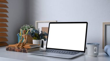 Bilgisayarı, kahve fincanını ve ofis malzemelerini beyaz masaya koyun..