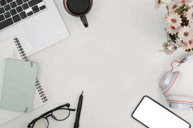 Bilgisayarlı ofis masası, akıllı telefon defteri ve kahve fincanı..