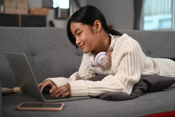 Young Asian Girl Lying Sofa Using Laptop Computer — Φωτογραφία Αρχείου