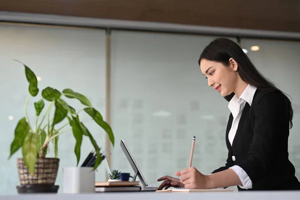 サイドビュー現代的なオフィスルームでコンピュータタブレットを使用して作業自信のあるビジネスマンの女性 — ストック写真