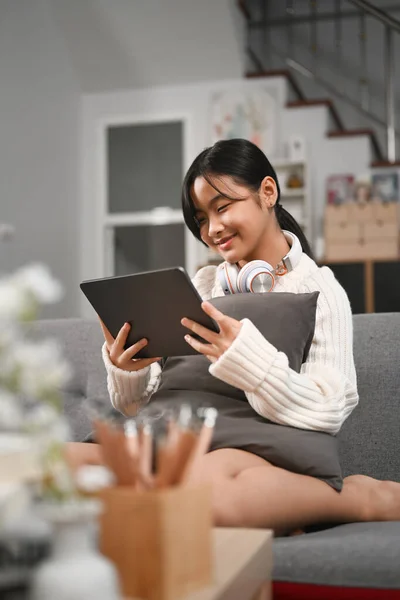 Cheerful Young Asian Girl Headphone Using Digital Tablet Couch — Stockfoto