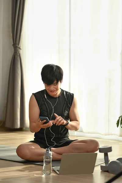 Deportista Escuchando Música Con Auriculares Usando Teléfono Inteligente Durante Ejercicio — Foto de Stock