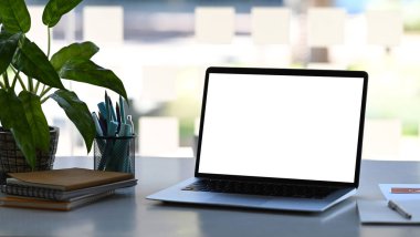 Tasarımcı rahat çalışma alanı ve pencerenin yanındaki boş ekran dizüstü bilgisayar. Ürün montajı için boş ekran.