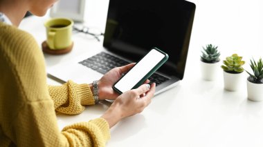 İş yerinde akıllı telefonları tutan kadın eli kesikleri. Metin iletiniz veya bilgi içeriğiniz için boş ekran.