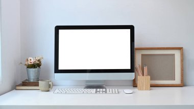 Minimum çalışma alanının ön görüntüsü. Beyaz masadaki bilgisayar esrar fabrikası, çerçeve, kahve fincanı gibi. Grafik görüntüleme kurgusu için boş ekran. 