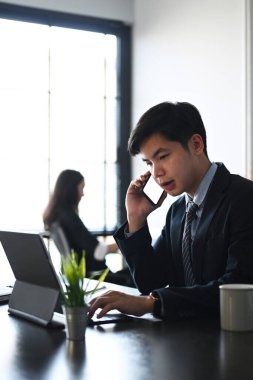 Bilgisayar tableti ve arka planda oturan meslektaşıyla yeni bir proje üzerinde çalışıyoruz..