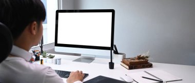 Bilgisayarın önünde çalışan genç grafik tasarımcısının arka görünümü.