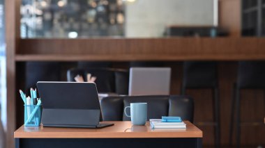 Tablet bilgisayarı, kahve fincanı, not defteri ve ahşap masasında kırtasiyesi olan yaratıcı tasarımcı işyeri.