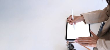 Beyaz masa üzerinde dijital tabletle çalışan fotoğrafçı ya da tasarımcının vesikalık fotoğrafı..