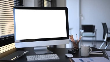 Ofiste bilgisayar, kahve fincanı, evrak ve kırtasiye malzemesi ile çalışabilir görünüm.