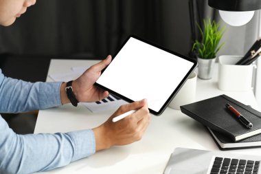 Grafik tasarımcısının, tablet üzerindeki stilus kalem ucunu kullanırken çekilmiş bir fotoğrafı. Ürün montajı için boş ekran.