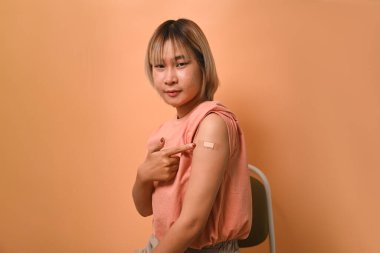 Bağışıklık aşısı olduktan sonra kollarını gösteren bir kadın. Aşılama ve aşılama.