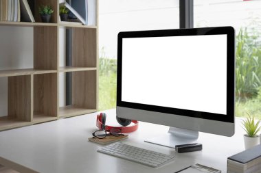 Beyaz masa üzerinde bilgisayar ve ofis malzemeleri olan modern işyeri.