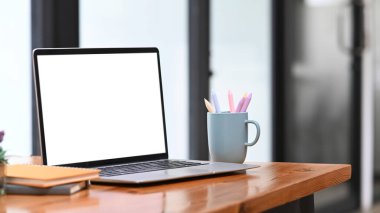 Bilgisayar, dizüstü bilgisayar, defter ve kahve fincanını ofis masasına yerleştir..