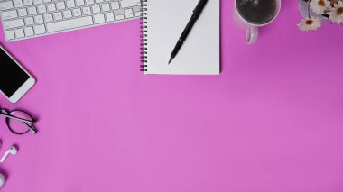 Cep telefonu defteri, kahve fincanı ve pembe arka planlı gözlüklü şık çalışma alanı