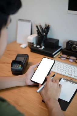 Ofis masasında oturan ve cep telefonu kullanan adam..