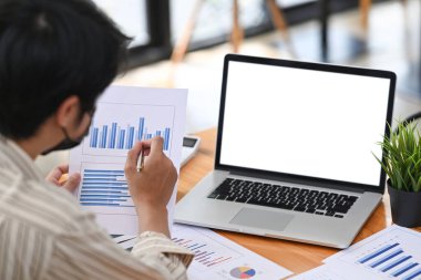 Dizüstü bilgisayarla çalışan ve mali raporları kontrol eden işadamlarının arka planı.