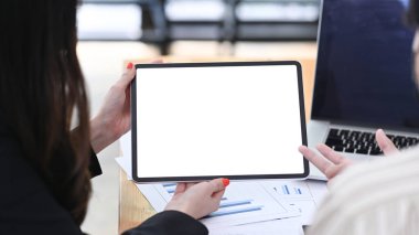 İki iş adamı dijital tablet kullanıyor ve toplantı odasında birlikte başlangıç projesi üzerinde çalışıyorlar.