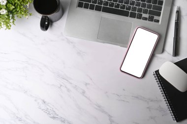 Cep telefonunu boş ekran, dizüstü bilgisayar ve mermer arka planda kahve fincanı ile taklit et.