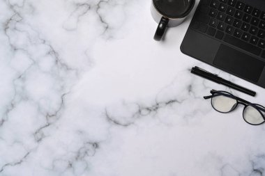 Üst görüş gözlüğü, kahve fincanı ve mermer arka planda bilgisayar tableti.