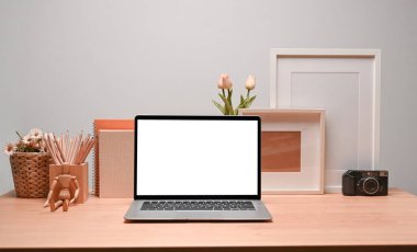 Dizüstü bilgisayarlı resim çerçevesi ve kalem tutacağı olan çağdaş işyeri.