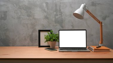 Ön manzara dizüstü bilgisayar, çerçeve, ev bitkisi ve lambayı ahşap masa üzerinde oluşturur..
