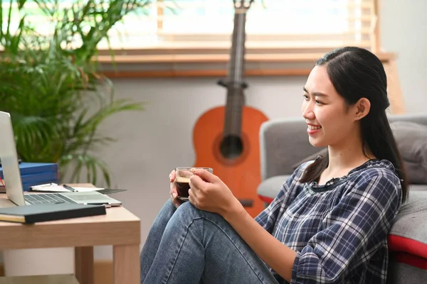 Leende Kvinna Som Håller Kaffekopp Och Använder Laptop Medan Sitter — Stockfoto