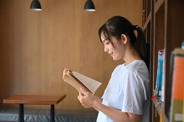 Zijaanzicht Van Jonge Aziatische Vrouw Lezen Boek Bibliotheek — Stockfoto