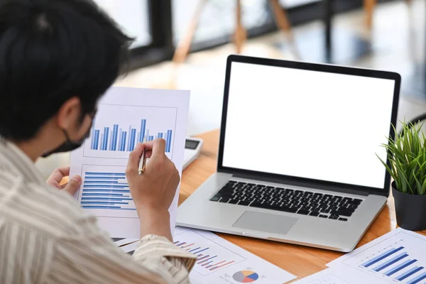 Dizüstü bilgisayarla çalışan ve mali raporları kontrol eden işadamlarının arka planı.