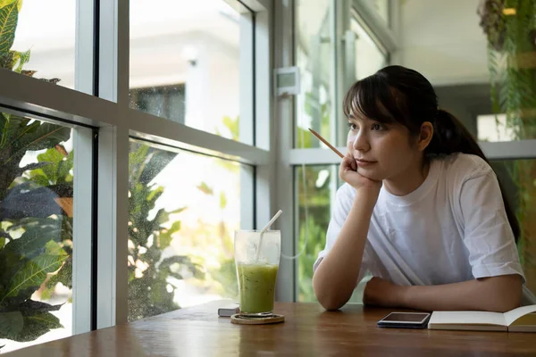 年轻女子坐在咖啡厅里 目瞪口呆 — 图库照片