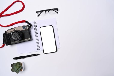 Fotoğrafçı çalışma alanına cep telefonu, kamera ve defter ekleyin..