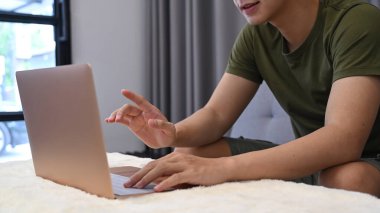 Kırpılmış adam internette dizüstü bilgisayarla sörf yapıyor..