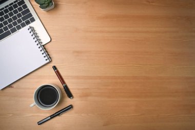 Bilgisayar laptopunu, not defterini ve kahve fincanını tahta zemine yapıştır..