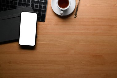 Akıllı telefon, klavye ve kahve fincanını ahşap masaya koy..