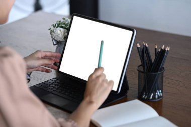 Ahşap masada bilgisayar tableti kullanan kadını kapat.