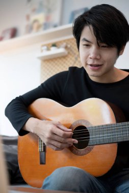 Kanepede gitar çalan mutlu adamın portresi..