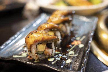 Siyah tabakta ızgara yılan balığı suşisi. Japon yemeği..