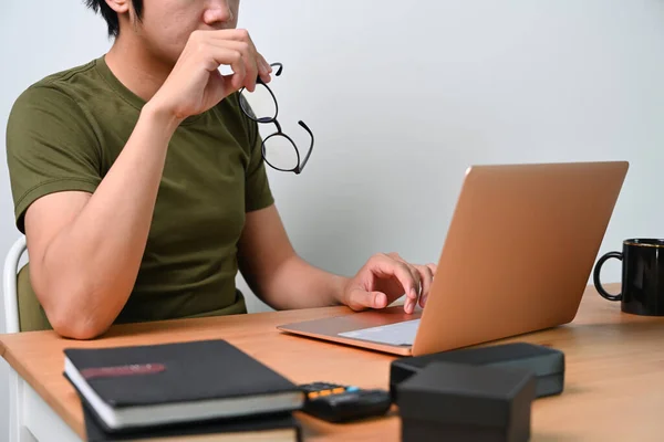 Giovane Uomo Tenendo Gli Occhiali Utilizzando Computer Portatile Casa — Foto Stock