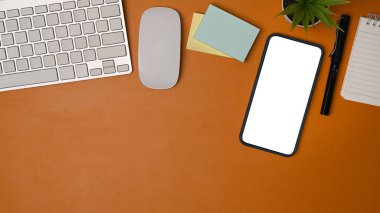 Üst görünüm akıllı telefon, yapışkan notlar ve kahverengi deri üzerine not defteri oluşturur..