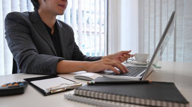 İşadamı modern ofis odasında dizüstü bilgisayarla çalışırken konsantre oluyor..