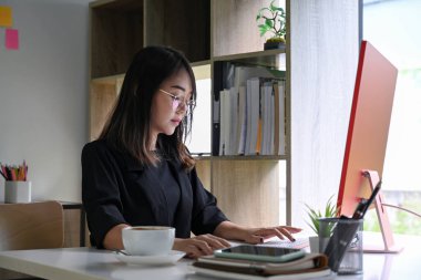 Bilgisayarla çalışan çekici bir iş kadını..