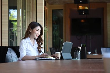 Gülümseyen iş kadını laptopta çalışıyor toplantı odasında oturuyor..