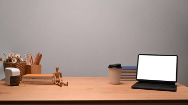 Bilgisayar tableti ve ofis malzemelerinin bulunduğu çağdaş iş yeri ahşap masada..
