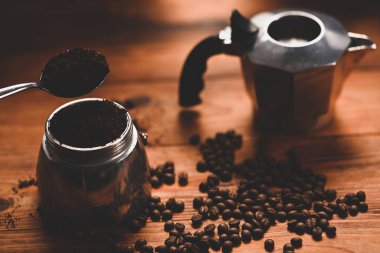 Kahve çekirdekleri ve kahve makinası ahşap arka planda..