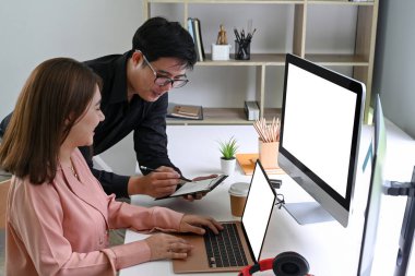 Modern ofiste bilgi tartışmak için dijital tablet kullanan iki iş arkadaşı.