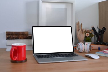 Bilgisayar dizüstü bilgisayarı, kulaklığı, kitapları ve kahve bardağı olan şık bir iş yeri.