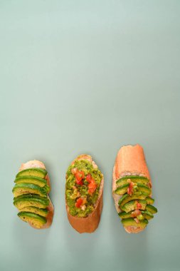 Avokado sandviçi yeşil arka planda. Sağlıklı meyve kavramı.